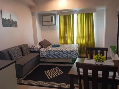 a small living room with a bed and a couch at Marlouise Place Beacon T1 in Manila