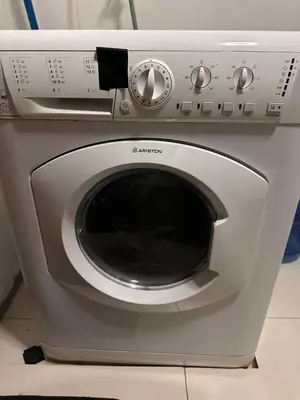 a silver washing machine sitting on top of a counter at COZI two bedroom family room near Grand Hyatt BGC in Manila