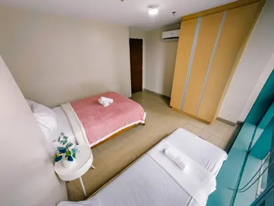 a small room with a bed and a sink at COZI two bedroom family room near Grand Hyatt BGC in Manila