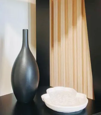 a black vase and a white plate on a table at Condo Staycation - Kanlungan by Anna at Satori Residences, Pasig in Manila