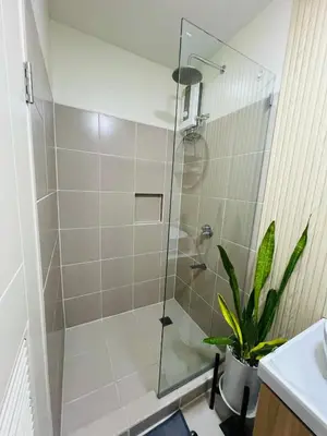 a shower with a glass door in a bathroom at Condo Staycation - Kanlungan by Anna at Satori Residences, Pasig in Manila