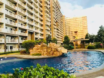 a large swimming pool in front of a large building at Condo Staycation - Kanlungan by Anna at Satori Residences, Pasig in Manila