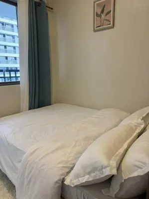 a white bed in a room with a window at Cozy 1BR nr Ortigas Makati & BGC with Secured Parking in Manila
