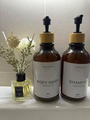 two bottles of body wash sitting on a shelf with flowers at Cozy 1BR nr Ortigas Makati & BGC with Secured Parking in Manila