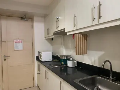 a kitchen with white cabinets and a sink at CASSa LISHA in Manila