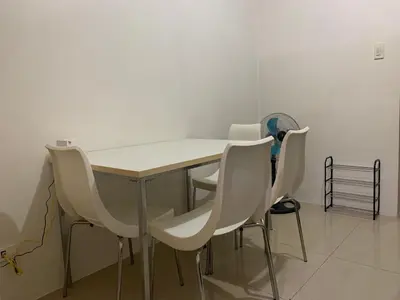 a dining room table with white chairs around it at CASSa LISHA in Manila