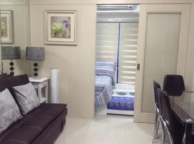 a living room with a couch and a bed at 7J HomeStay at Sea Residences MoA Manila in Manila