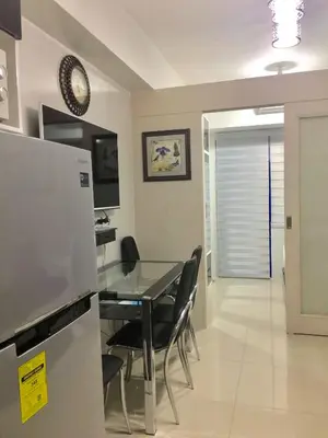 a kitchen and dining room with a table and chairs at 7J HomeStay at Sea Residences MoA Manila in Manila