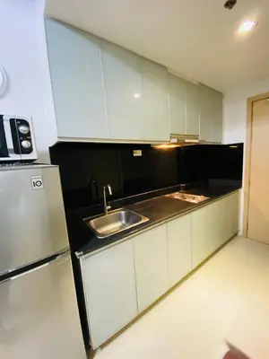 a kitchen with a sink and a refrigerator at 7J HomeStay at Sea Residences MoA Manila in Manila