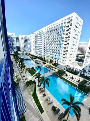 an overhead view of a large building with a large swimming pool at Flores Place At Sea Residences MOA in Manila