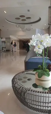 a vase of flowers on a table in a lobby at Flores Place At Sea Residences MOA in Manila