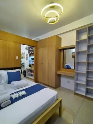 a bedroom with a large bed and a chandelier at Comfystay at Shell Residences in Manila