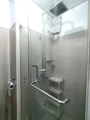 a shower in a bathroom with a glass door at Comfystay at Shell Residences in Manila