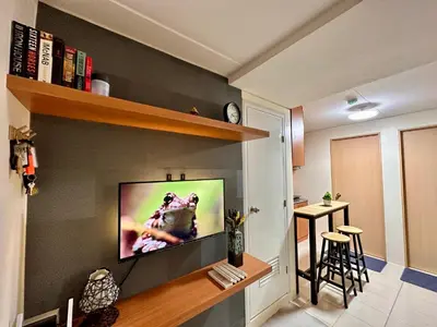 a living room with a flat screen tv on a wall at VR Homes Ortigas - 2BR Condo with Free WiFi & Netflix in Manila