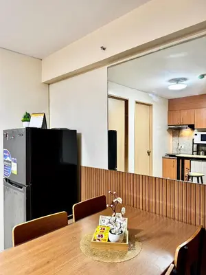a dining room with a table and a refrigerator at VR Homes Ortigas - 2BR Condo with Free WiFi & Netflix in Manila