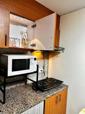 a kitchen with a microwave and a stove at VR Homes Ortigas - 2BR Condo with Free WiFi & Netflix in Manila