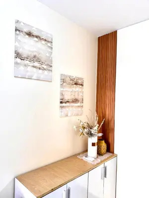 a room with a counter with two paintings on the wall at VR Homes Ortigas - 2BR Condo with Free WiFi & Netflix in Manila
