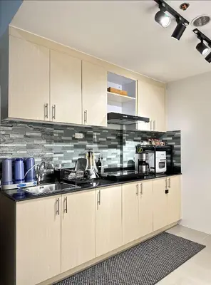 a kitchen with a sink and a microwave at Suite 101F a New & Spacious MOA Sunrise Drive Oasis in Manila