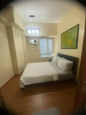 a bedroom with a bed and a window in it at 1Bdrm Condo at Makati w Balcony view of Mnla Bay in Manila