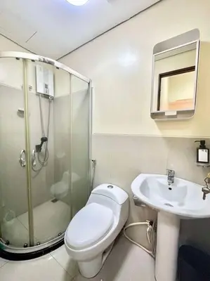 a bathroom with a shower and a toilet and a sink at 1Bdrm Condo at Makati w Balcony view of Mnla Bay in Manila