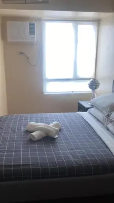 a bed with a towel on top of it at 1Bdrm Condo at Makati w Balcony view of Mnla Bay in Manila