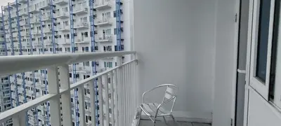 a chair sitting on a balcony next to a building at Aircon Budget Room for 4 persons in Makati in Manila