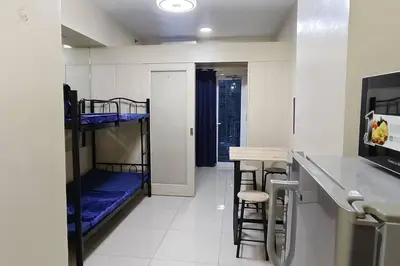 a room with two bunk beds and a table and chairs at Aircon Budget Room for 4 persons in Makati in Manila