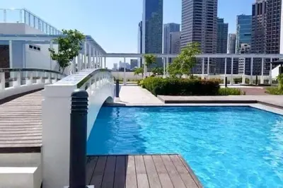 a swimming pool with a city skyline in the background at Jazz Residences Tower D 1BR in Manila