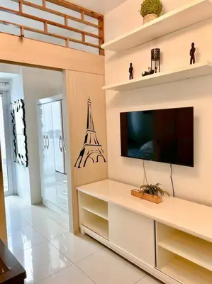 a living room with a flat screen tv on a wall at Jazz Residences Tower D 1BR in Manila
