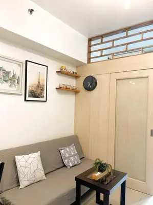 a living room with a couch and a table at Jazz Residences Tower D 1BR in Manila
