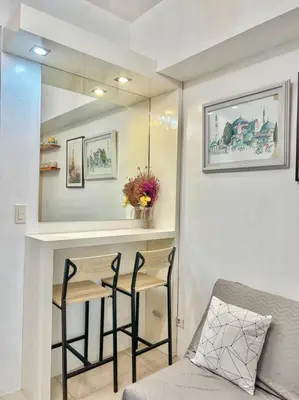 a living room with a bar with two stools at Jazz Residences Tower D 1BR in Manila