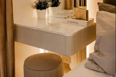 a table with a stool next to a bed at Lamour Talia in Manila