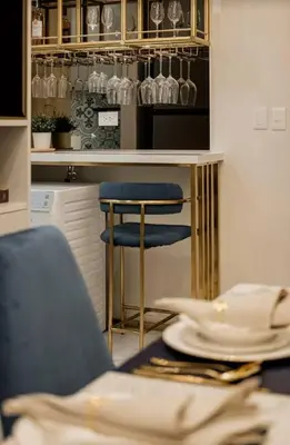 a kitchen with a bar with plates and a chair at Lamour Talia in Manila