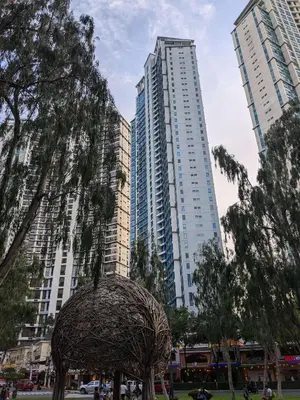 two tall buildings with a sculpture in a park at Bellagio One Bedrroom BGC Burgos Circle by Christine Suites PH in Manila