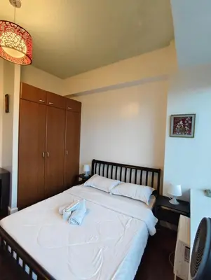 a bedroom with a bed with a towel on it at Bellagio One Bedrroom BGC Burgos Circle by Christine Suites PH in Manila
