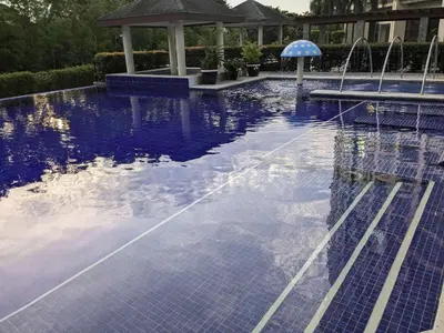 a swimming pool with a blue tile floor and a gazebo at Bellagio One Bedrroom BGC Burgos Circle by Christine Suites PH in Manila