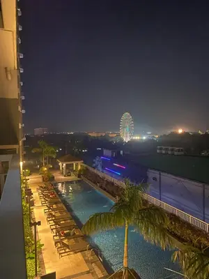 a view of a swimming pool at night with a ferris wheel at SMDC Coast Residences in Manila