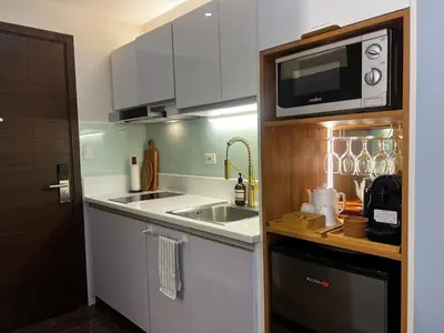 a small kitchen with a sink and a microwave at BRAND NEW Casa Airabella with Netflix & Makati City Skyline in Manila