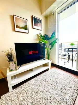 a living room with a flat screen tv on a tv stand at CASA SOPHIA Affordable Condo Near Bonifacio Global City BGC CBD in Manila