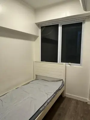 a small bedroom with a bed and a window at Cozi Modern Loft Suite near high street BGC wifi pool in Manila