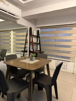 a dining room with a wooden table and chairs at Cozi Modern Loft Suite near high street BGC wifi pool in Manila