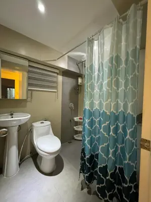 a bathroom with a toilet and a sink at Cozi Modern Loft Suite near high street BGC wifi pool in Manila