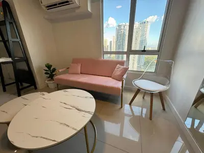 a living room with a couch and a chair at Cozi Modern Loft Suite near high street BGC wifi pool in Manila
