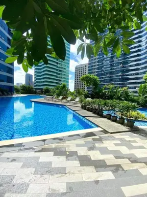 a large swimming pool in a city with tall buildings at Air Residence in Manila