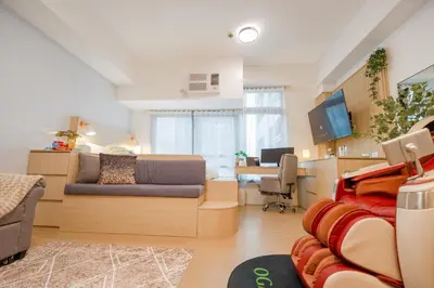 a living room with a couch and a desk at Eastwood LeGrand 3 with Ogawa MasterdrivePlus, No Pets Allowed in Manila