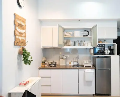 a kitchen with white cabinets and a counter top at Eastwood LeGrand 3 with Ogawa MasterdrivePlus, No Pets Allowed in Manila