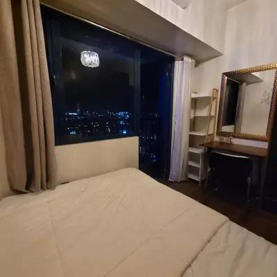 a bedroom with a large window with a city view at Air Residences - Panoramic City View near Airport - 2932 in Manila