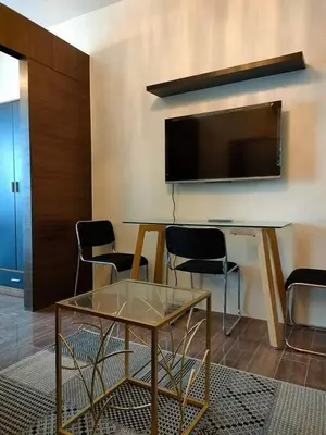 a room with a table and a tv and chairs at Air Residences - Panoramic City View near Airport - 2932 in Manila