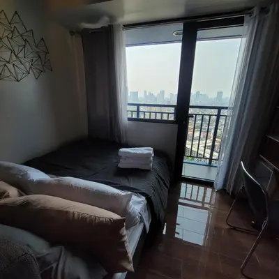 a room with two beds and a large window at Air Residences - Panoramic City View near Airport - 2932 in Manila