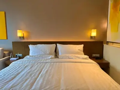 a bedroom with a large bed with two pillows at The Residences at Novotel Tower in Manila